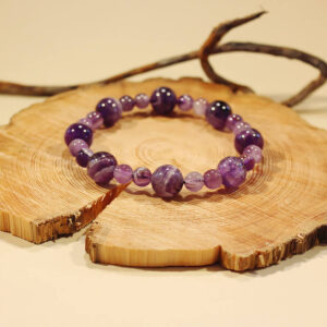 Ett armband med ametist på en träskiva