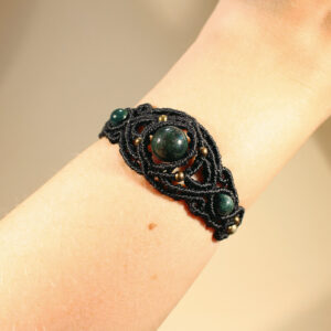 Ett svart makraméarmband med grön agat och bronsfärgade pärlor