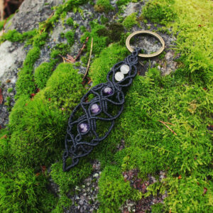 En svart nyckelring i makramé med pärlor av bergkristall och ametist