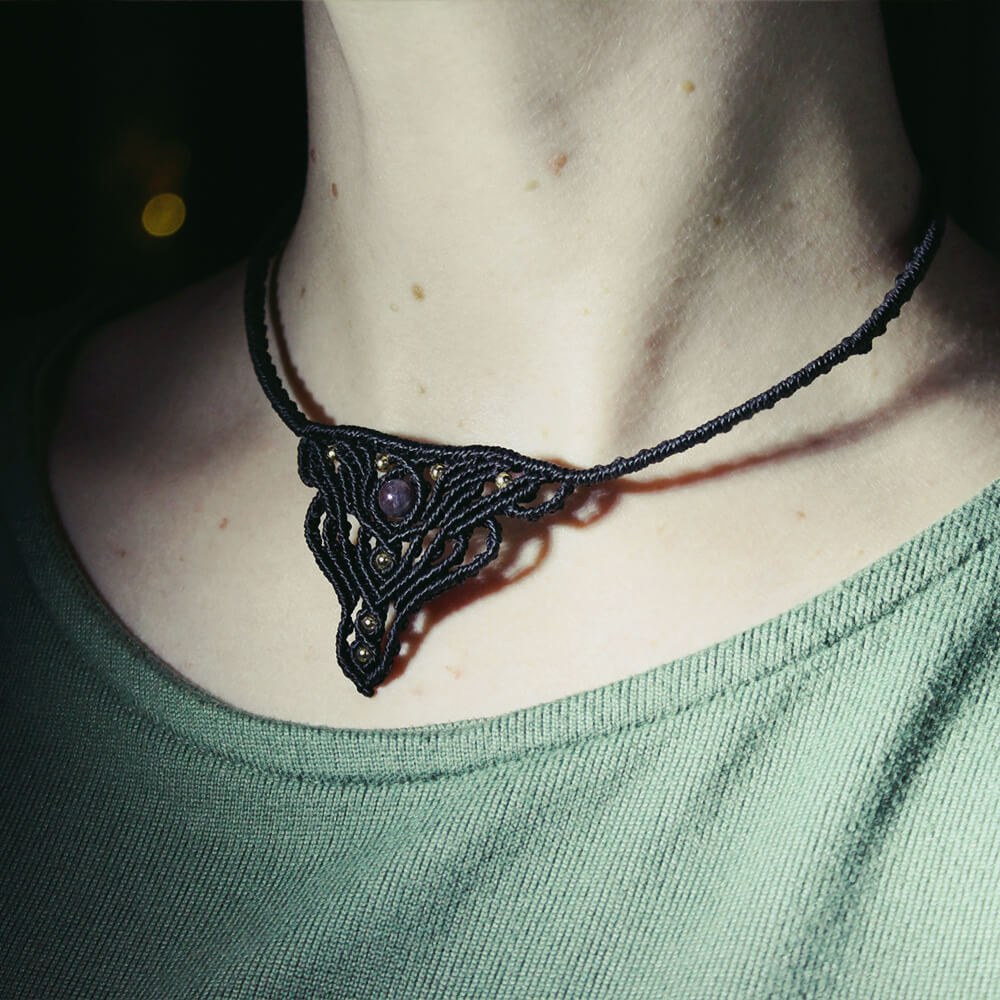 Kort halsband med ametist knutet i makram&eacute;, med m&auml;ssingskulor.