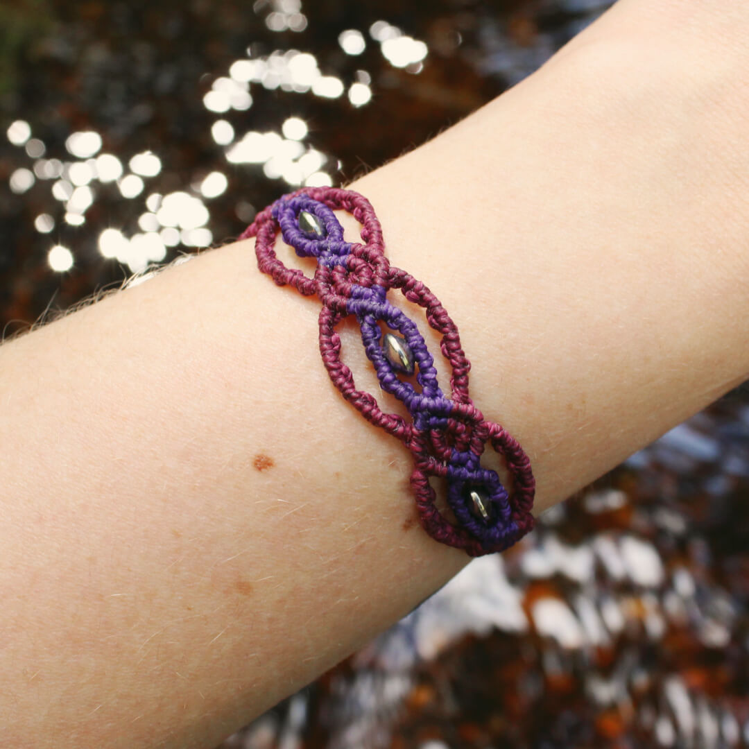 Lila makram&eacute; armband med p&auml;rlor i rostfritt st&aring;l